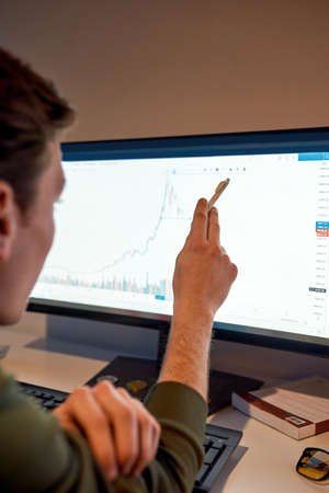 Trader watch and point on graph on computer