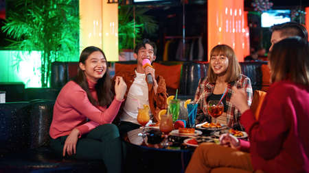 Asian friends enjoying friendship together in karaoke bar