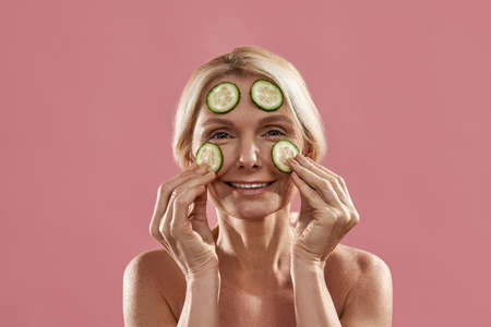 Portrait of woman apply cucumber slices on faceの写真素材