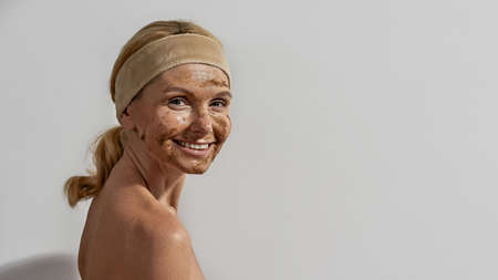 European woman with coffee and salt scrub on faceの写真素材