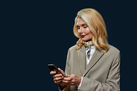 Adult businesswoman browse or watch on smartphoneの写真素材