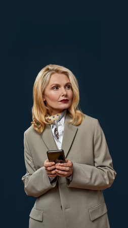 Mature businesswoman use smartphone and look away