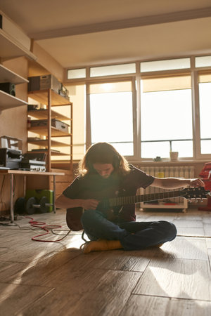Caucasian man tun electric guitar before playの写真素材