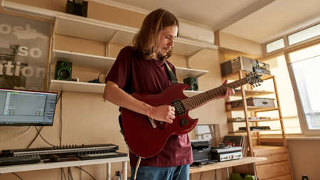Young rock musician play electric guitar at home