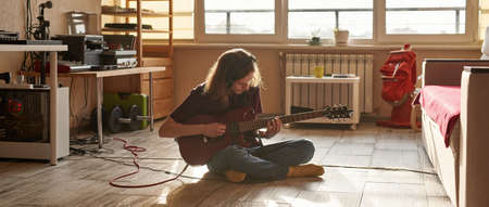 Young european grunge man playing electric guitar