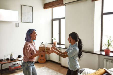 Young girl gives nice wrapped gift to her friendの写真素材