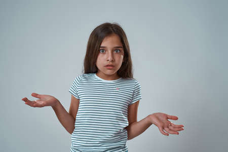 Little girl with skeptical face looking at cameraの写真素材