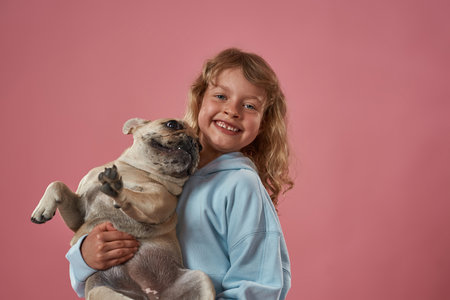 Happy caucasian little girl holding French bulldogの写真素材