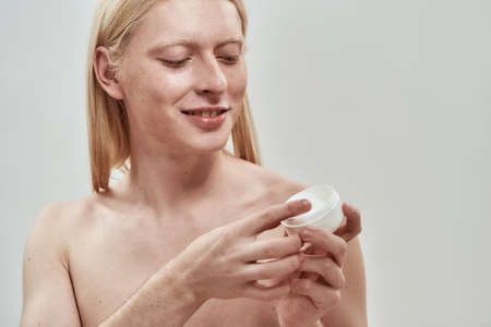 Partial of guy take cosmetic cream from container
