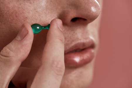 Obscure face of guy holding beauty capsuleの写真素材