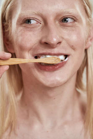 Obscure face of guy brushing teeth with toothpasteの写真素材