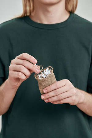 Cropped of guy taking cotton ear stick from bagの写真素材