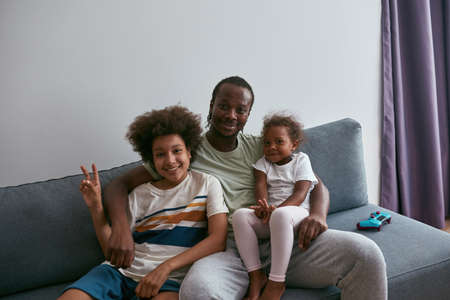Black family resting and showing victory gestureの写真素材