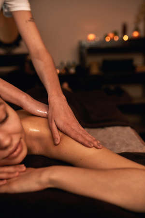 Obscure face of masseur do back massage of womanの写真素材