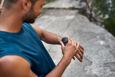 Partial view of sportsman use smartwatch outdoorsの写真素材