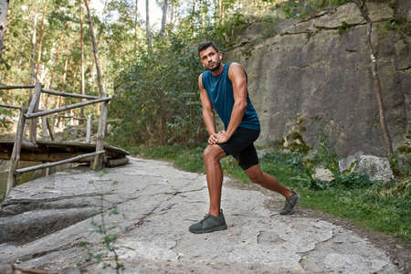 Sportsman warming up and looking away outdoors