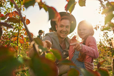 Surprised dad and smiling daughter point on plantの写真素材