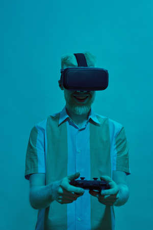 Guy wearing VR glasses play video game on joystick