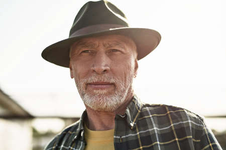 Portrait of cropped elderly male farmer look away