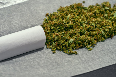 Cropped close up of dry crushed marijuana on paperの写真素材