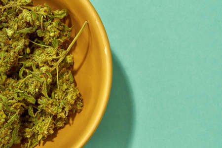 Partial close up of bowl with dry marijuana buds