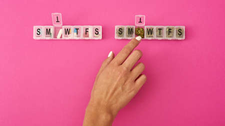 Woman taking marijuana bud from package near pillsの写真素材