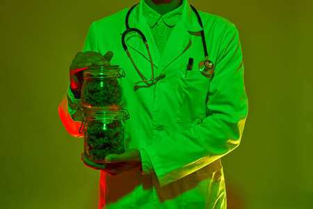 Partial of doctor holding jars with marijuana budsの写真素材