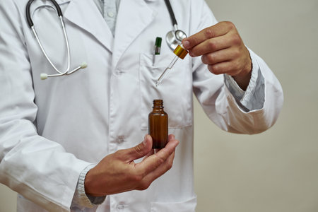 Partial of male doctor taking dropper from bottleの写真素材