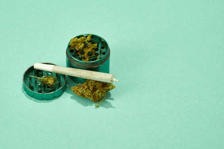 Jar with crushed marijuana buds and rolled joint