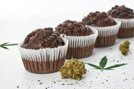 Cropped of cupcakes in row with green marijuanaの写真素材