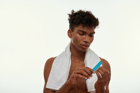 Black guy do fingernails manicure with nail fileの写真素材