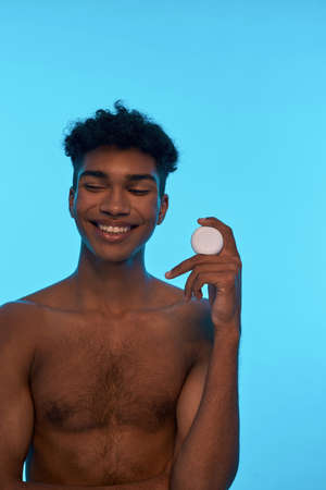 Young black guy holding and showing dental flossの写真素材