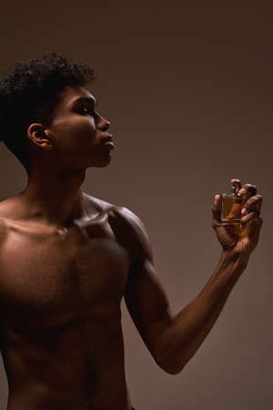 Handsome guy applying aromatic perfume on himselfの写真素材