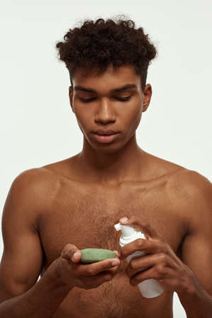 Partial of black guy pouring cream on washclothの写真素材
