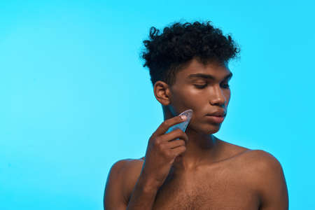 Partial of black guy applying ice slice on faceの写真素材