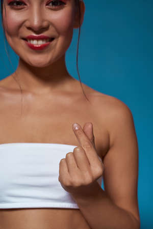 Cropped of smiling asian girl crossing fingersの写真素材