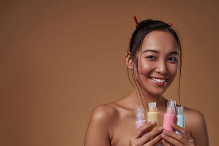 Girl holding nail polishes and looking at camera