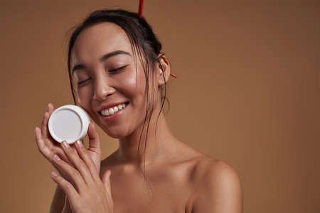 Stylish girl with container of cosmetic creamの写真素材