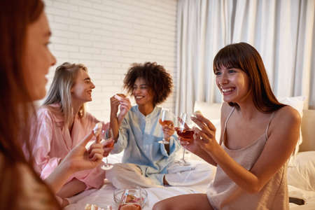 Girls drink wine and feed marshmallow each otherの写真素材