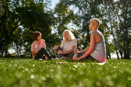 Woman looking at cheerful senior couple in parkの写真素材