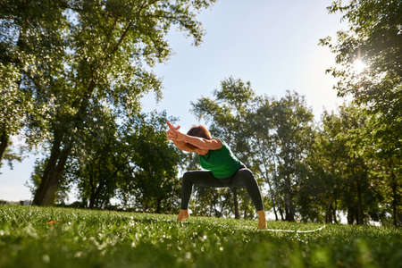 Caucasian middle aged woman practice yoga in parkの写真素材