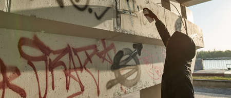 Man draw graffiti letters and symbols on buildingの写真素材