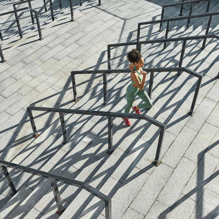 Top of young black sportswoman run on staircaseの写真素材