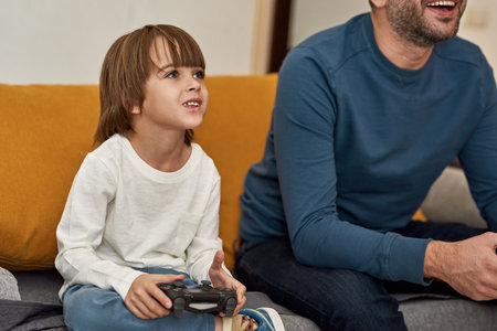 Little boy and partial father playing video game