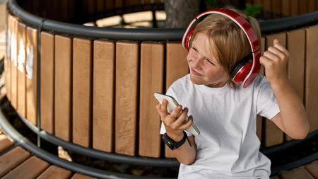 Boy listening music in earphones on smartphoneの写真素材