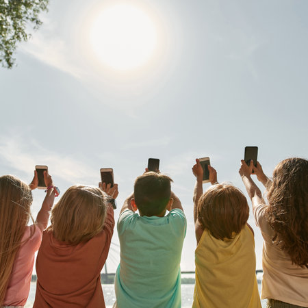 Kids taking photo of solar eclipse on smartphones