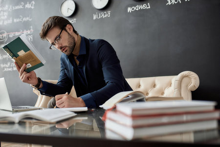 Smart IT investor writing notes from reading bookの写真素材