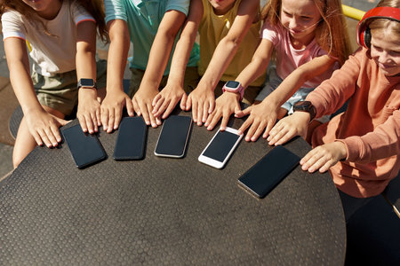Children spin on rotating swing with smartphonesの写真素材