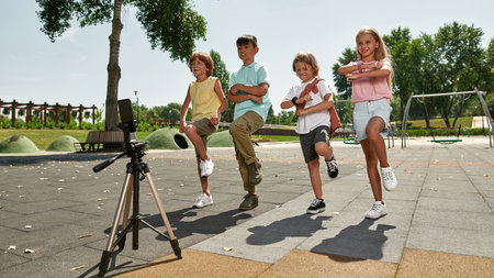 Kids dance for make video on smartphone outdoorsの写真素材
