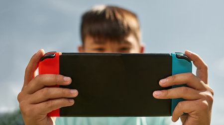 Focus of game console in hands of cropped blur boyの写真素材